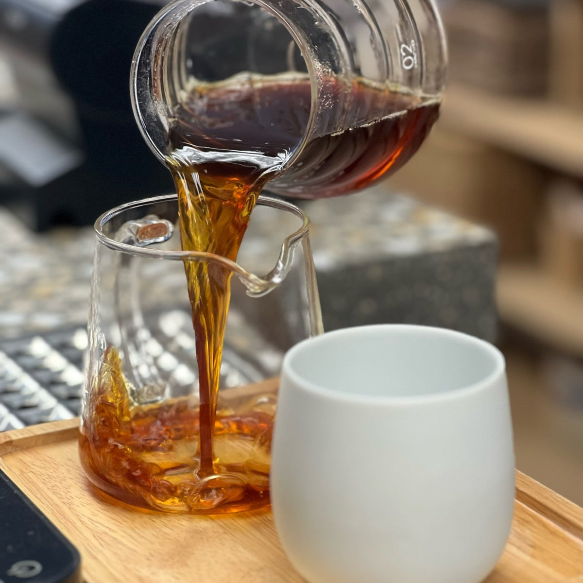 Pouring coffee from a glass pitcher into a cup, highlighting the essence of the AUTUMN GIFT SUBSCRIPTION.