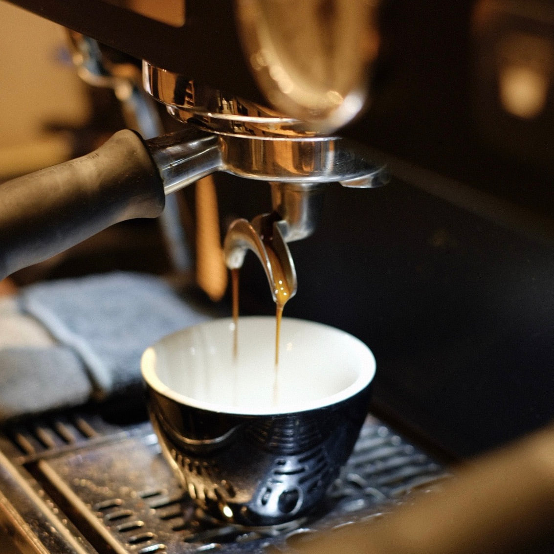 Espresso being poured from a machine into a cup.