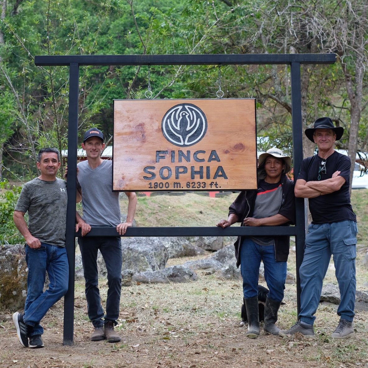 Group of four coffee producers standing by the Finca Sophia sign, showcasing the heritage of FINCA SOPHIA GESHA.