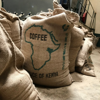 Burlap sacks of green coffee beans from Kenya stored at a coffee processing facility