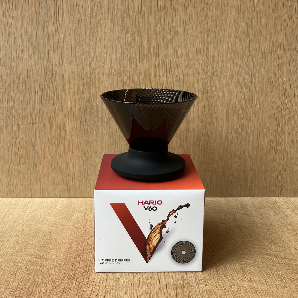 HARIO V60 NEO coffee dripper displayed with elegant design and packaging on a wooden surface.