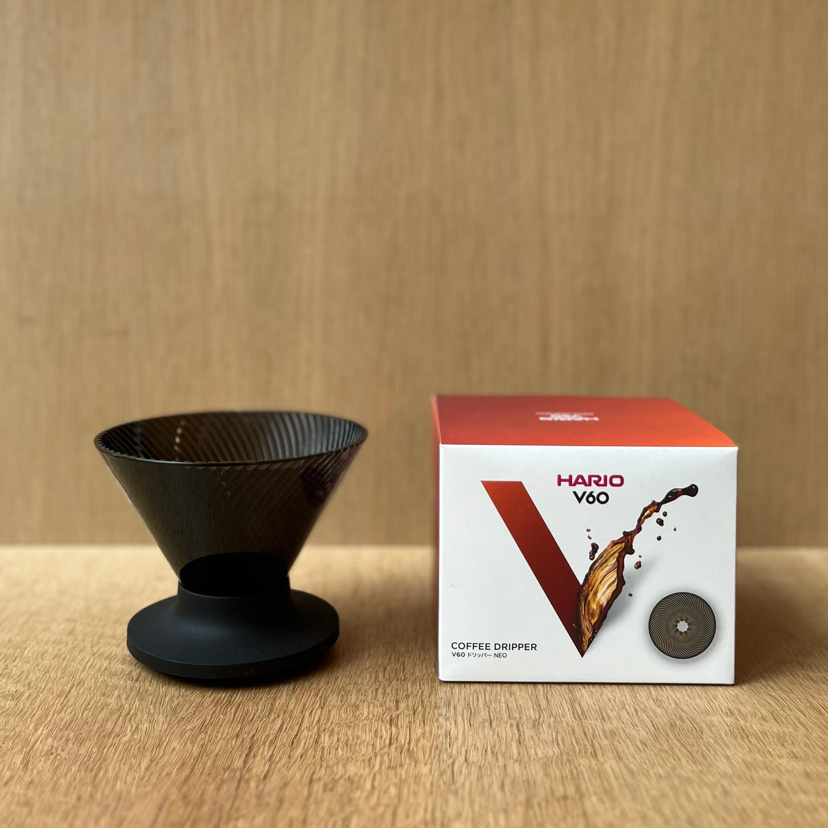 HARIO V60 NEO coffee dripper with innovative design on wooden background.