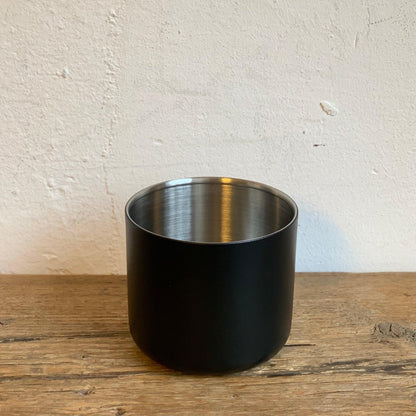 ATMOS ELECTRIC VACUUM CANISTER in matte black stainless steel on a wooden surface.
